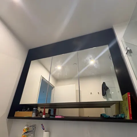 Custom black-framed bathroom mirror above a vanity, Brisbane