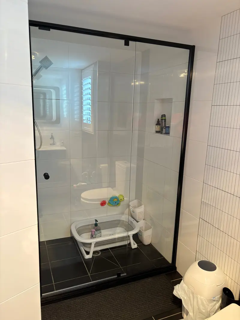Black-framed semi-frameless shower enclosure