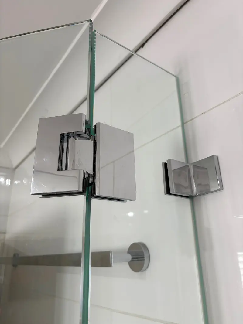 Chrome glass-to-glass shower hinge detail