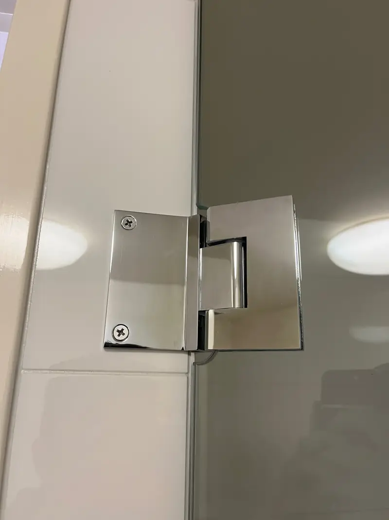 Chrome shower screen hinge close-up