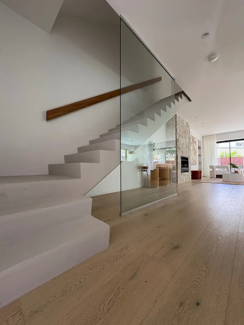 Frameless glass balustrade beside a timber staircase