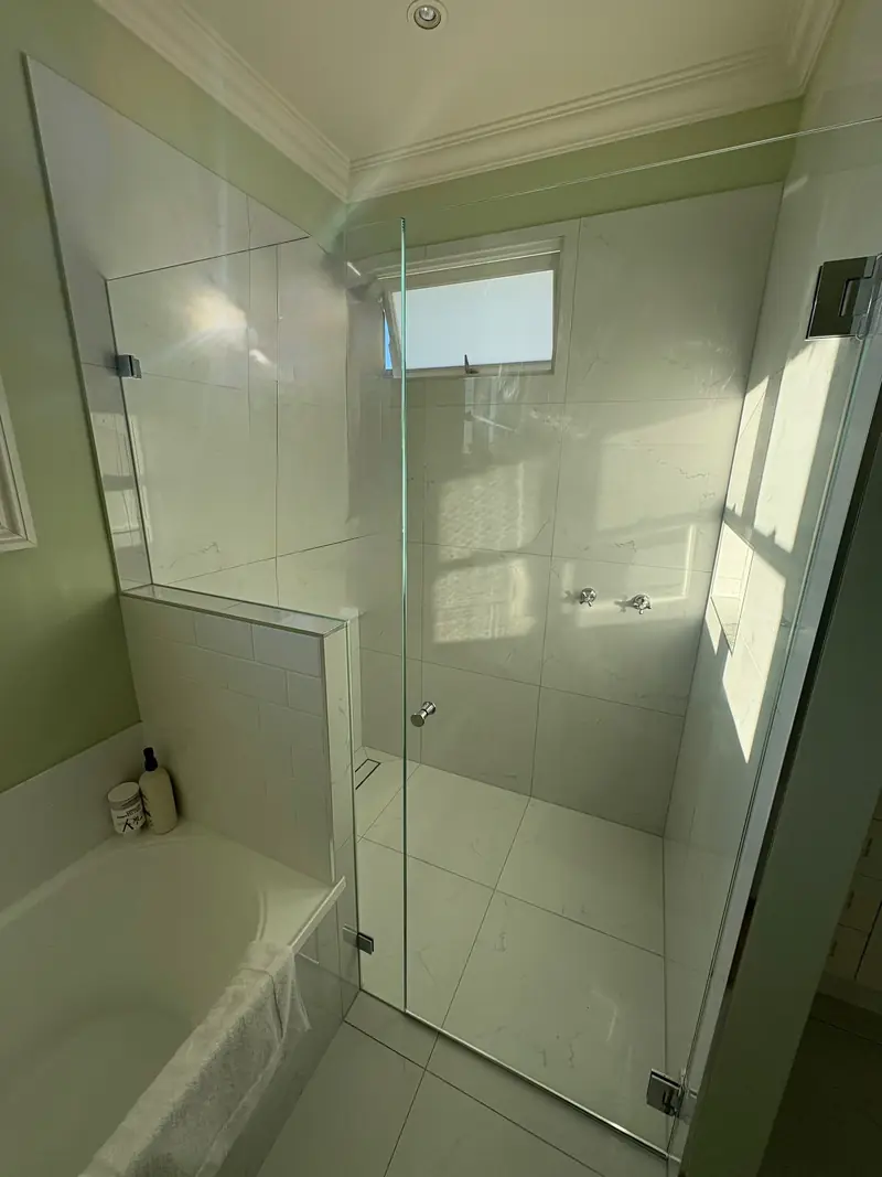 Frameless shower screen installed next to a bathtub