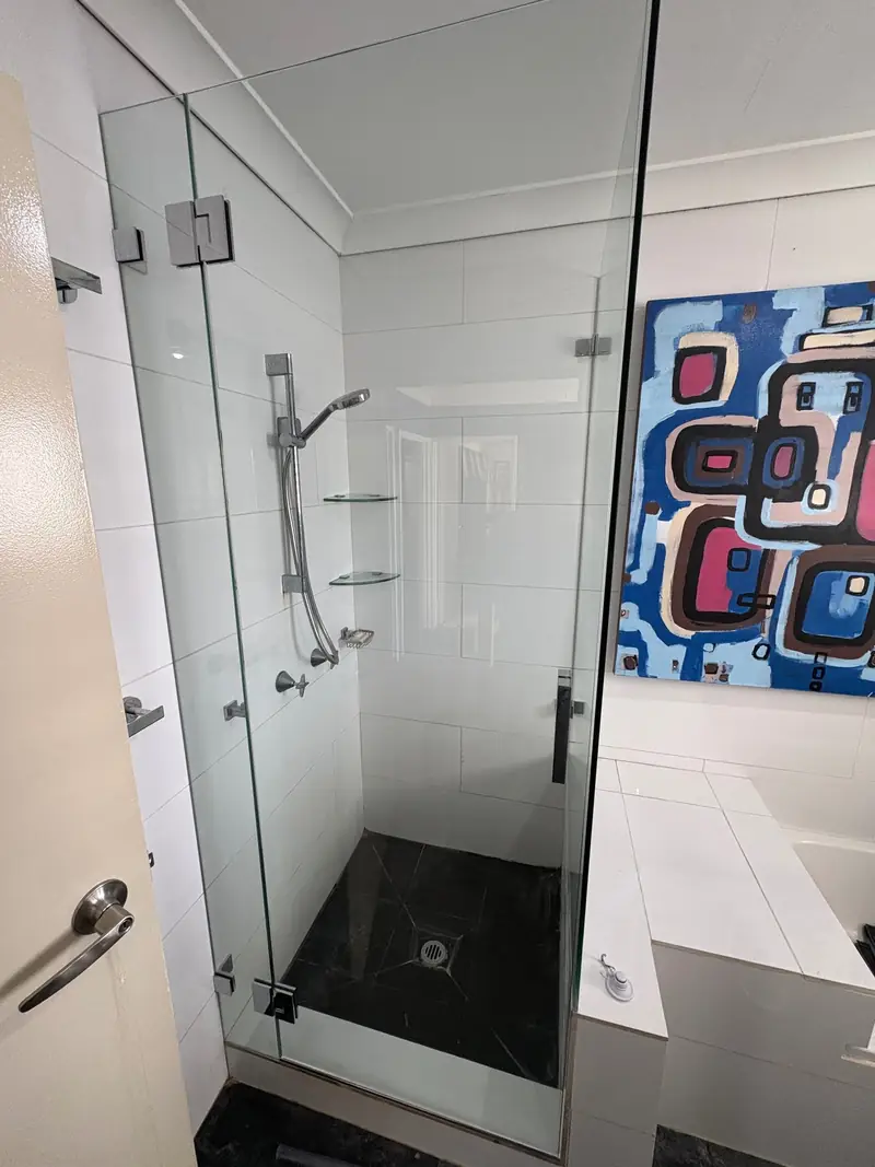 Frameless shower screen with corner return panel