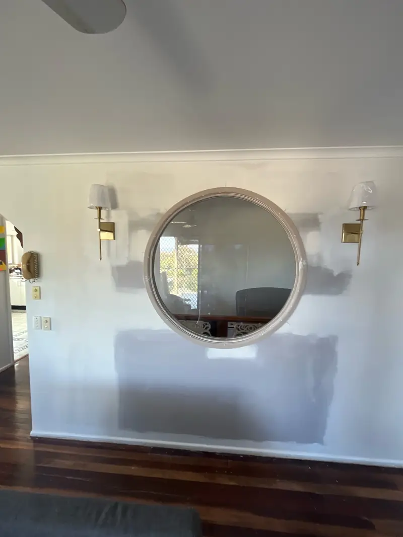 Round frameless bathroom mirror above a vanity