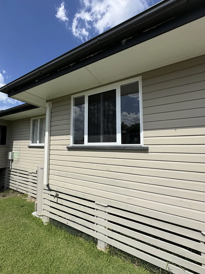 Weatherboard home exterior with new white aluminium sliding windows, Brisbane