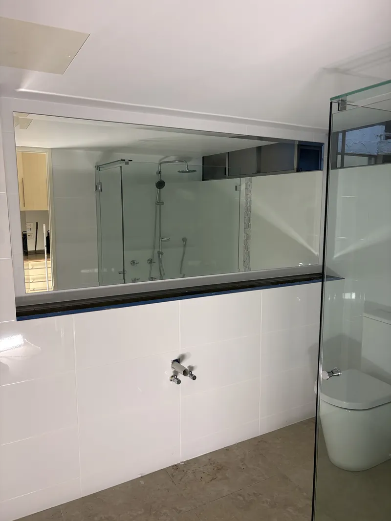 Wide frameless bathroom mirror reflecting a frameless shower screen, Brisbane